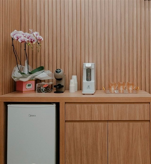 Cantinho de café com orquídeas e água para receber as pacientes